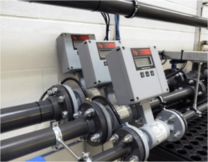 Technician performing flow meter calibration at Caltech