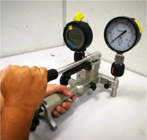 Technician performing pressure gauge calibration at Caltech